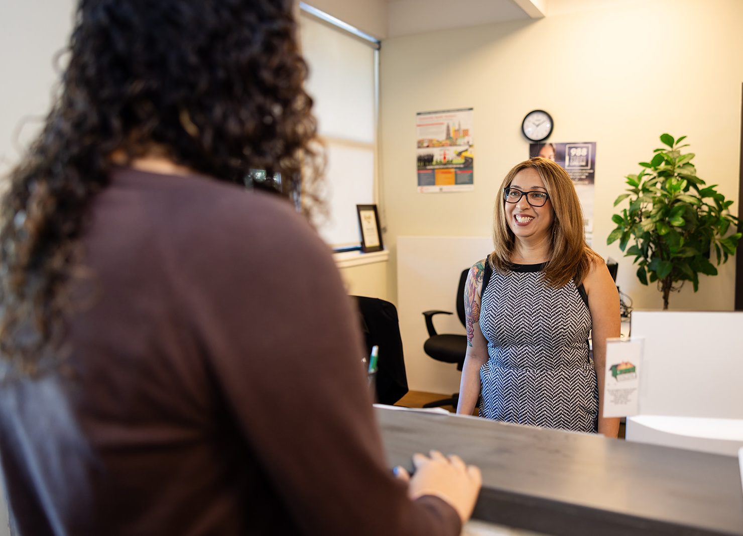 Hanna Center staff member welcoming a community member at the Mental Health & Wellness reception desk.