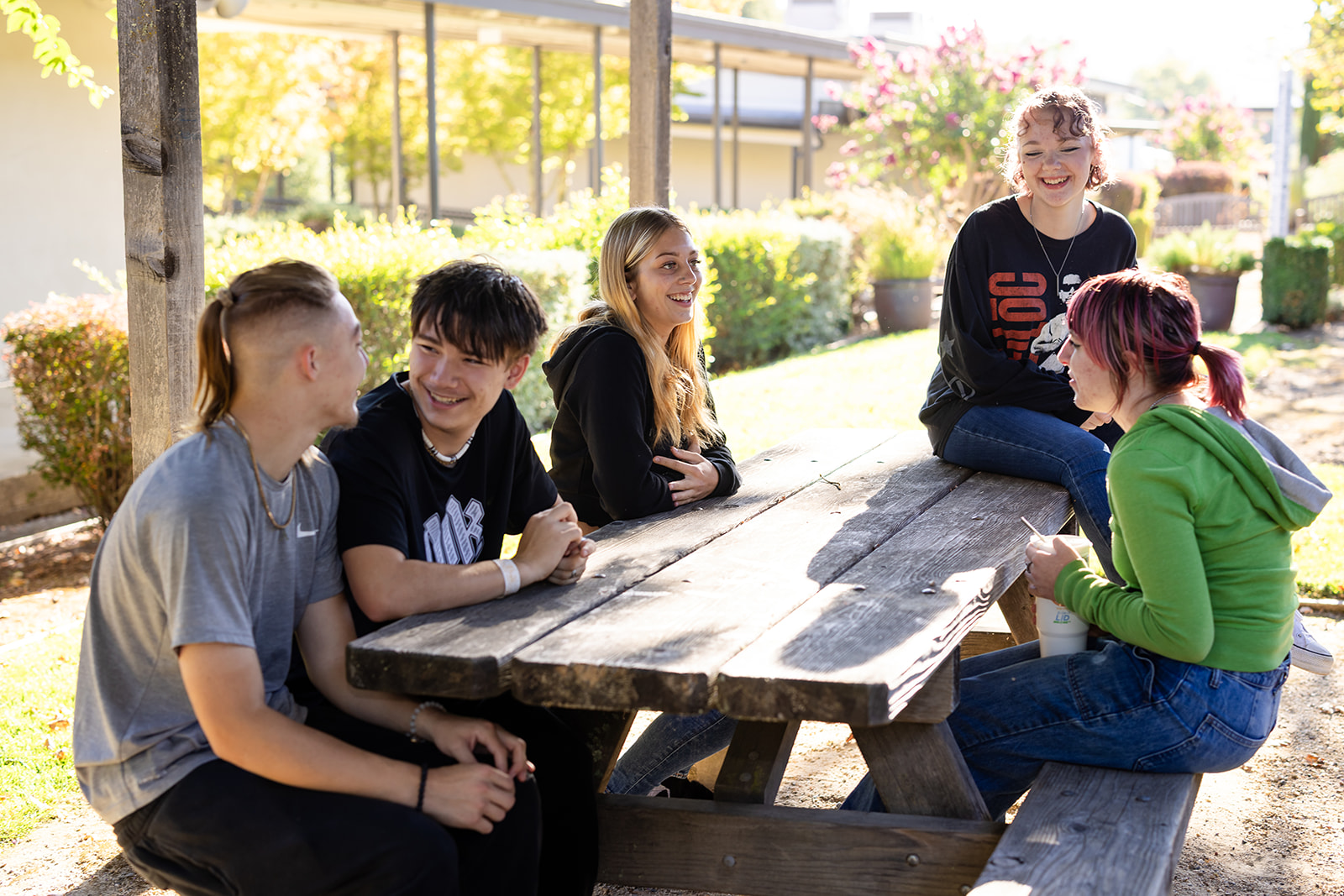 Students gather around a picnic table on Hanna Center’s Sonoma campus, smiling and connecting outdoors.