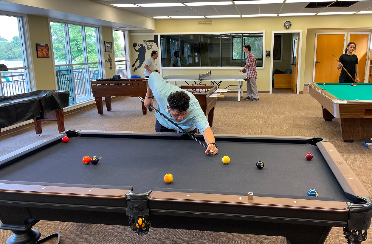 Students playing billiards inside Hanna Center recreation center.