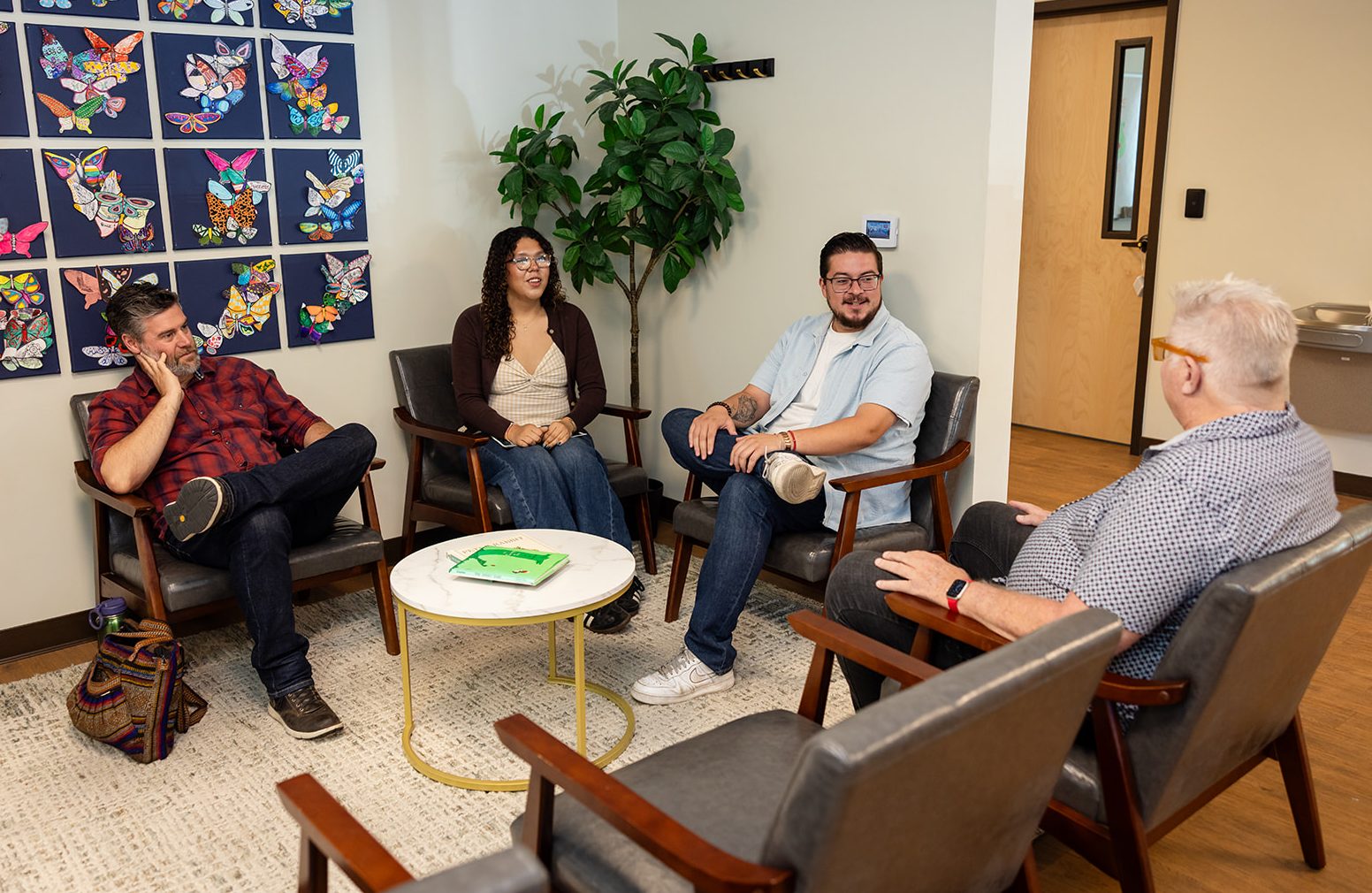 Hanna Center Mental Health & Wellness team members sit together in a welcoming therapy room for a group conversation.
