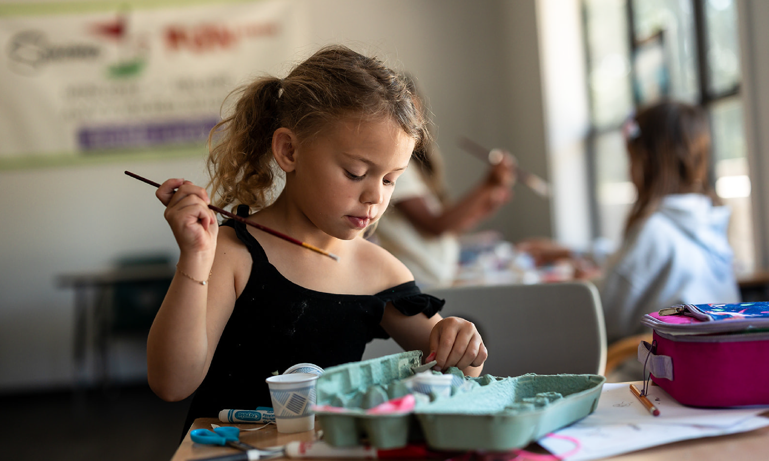 Child painting at Hanna Center Camps.