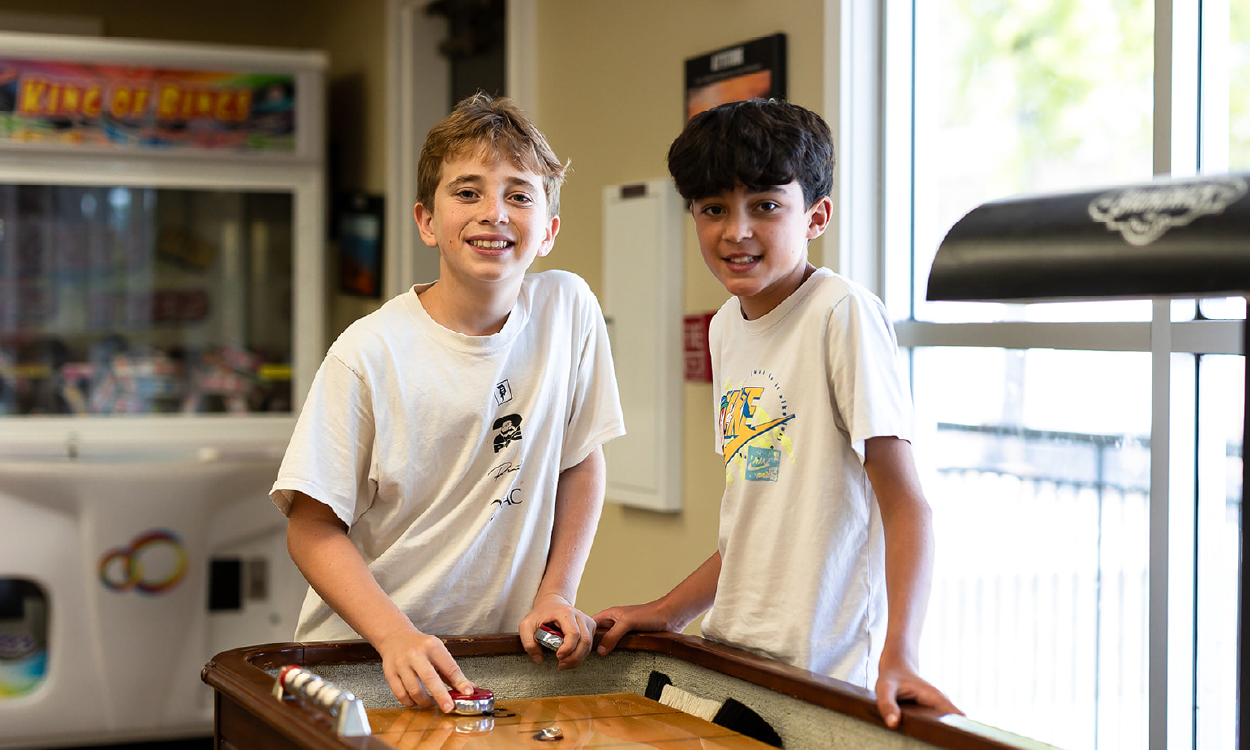 Two campers playing shuffleboard in the Hanna Recreation Center.