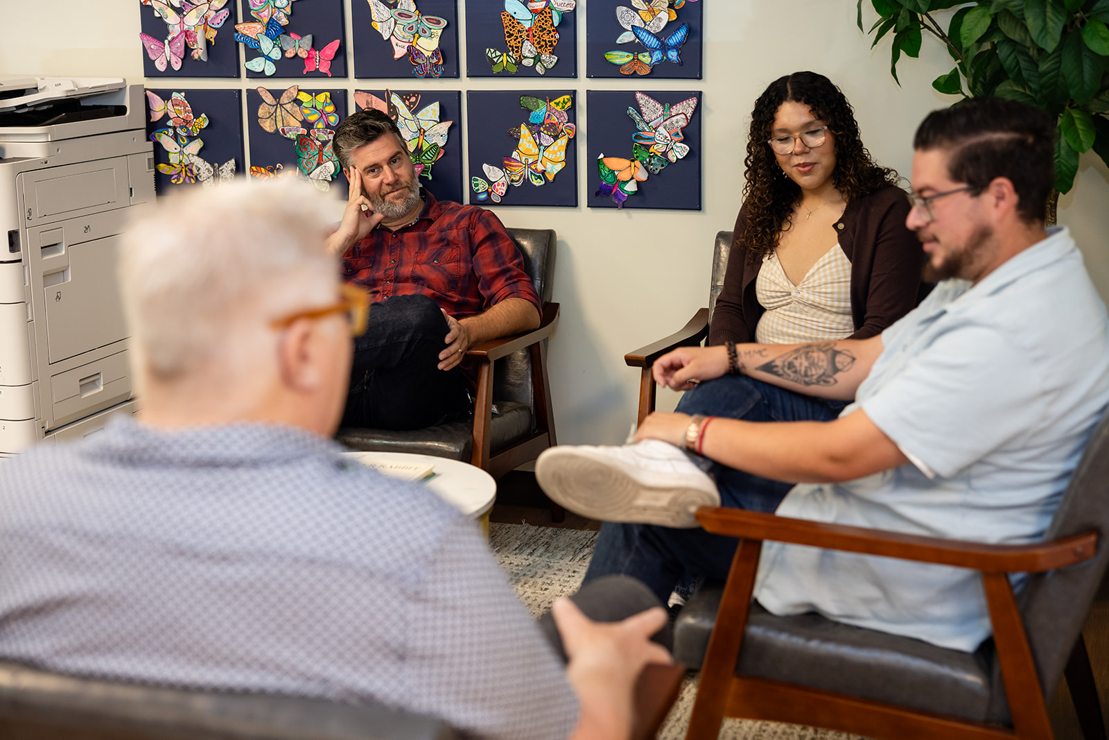 Group of people sitting in a waiting room, chatting.